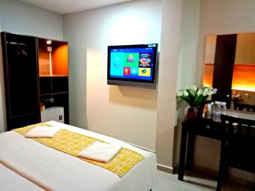 a room with a bed and a tv on a wall at Eazy Hotel at Ampang in Batu Empat