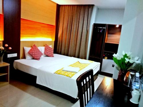 a bedroom with a white bed with red pillows at Eazy Hotel at Ampang in Batu Empat