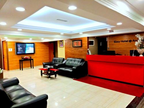 a waiting room with leather furniture and a red counter at Eazy Hotel at Ampang in Batu Empat