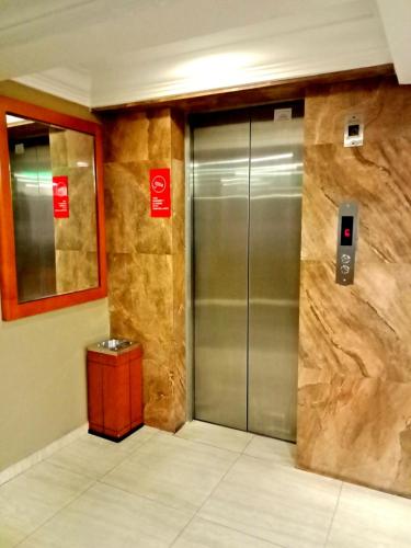 an elevator in a building with a metal door at Eazy Hotel at Ampang in Batu Empat