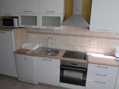 a kitchen with white cabinets and a sink at Apartments Villa Bella Vista Hvar in Hvar