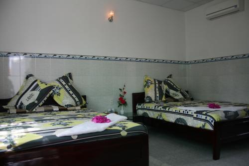1 dormitorio con 2 camas con flores en Duc Thao Guest House, en Mui Ne