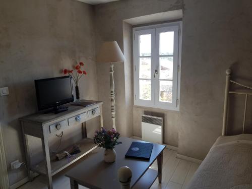 a small living room with a television and a table at Le Crillon in Murs