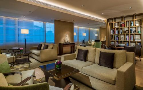a living room with couches and chairs and a table at Fraser Suites Guangzhou in Guangzhou