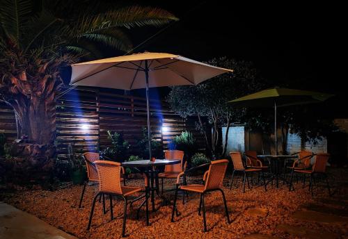 a table and chairs with an umbrella at night at Hostel Once Once in Villa de Leyva