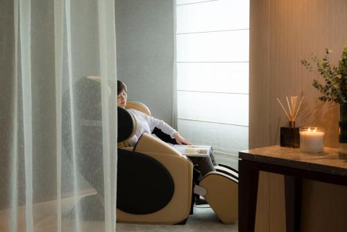 a woman sitting in a chair in a room at Fraser Suites Guangzhou in Guangzhou