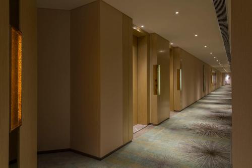 a corridor of a building with brown walls and carpet at Fraser Suites Guangzhou in Guangzhou