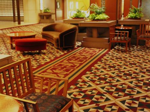 a lobby with a patterned floor with chairs and tables at Imperial Hotel Osaka in Osaka