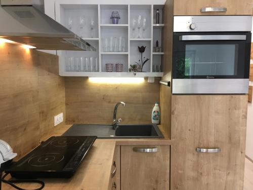a kitchen with a sink and a stove at Szende Apartman in Balatonfüred