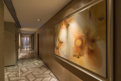 a hallway with a large painting on the wall at Fraser Suites Guangzhou in Guangzhou