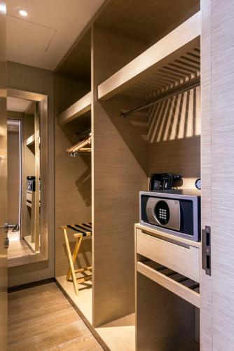 a walk in closet with a microwave on a counter at Fraser Suites Guangzhou in Guangzhou
