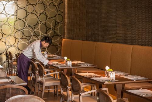 a woman standing at a table in a restaurant at Fraser Suites Guangzhou in Guangzhou