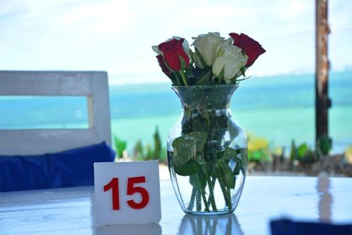 a vase with roses in it sitting on a table at Ocean View Nyali Boutique Hotel in Nyali