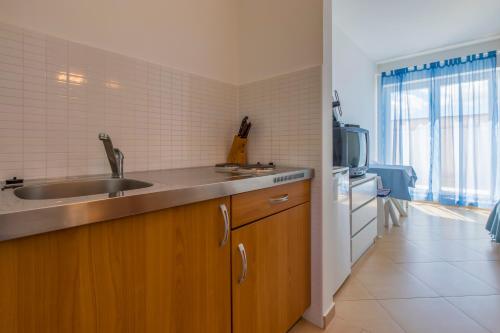 a kitchen with a sink and a microwave at Apartmani Mirta in Dramalj