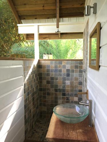 La salle de bains est pourvue d'un lavabo en verre sur une table. dans l'établissement Bird Island Bungalows, à Bocas del Toro