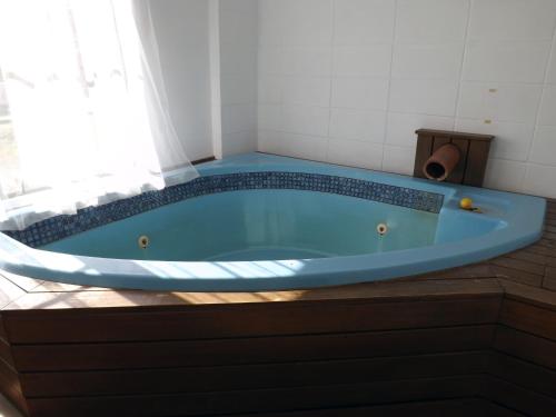 a blue tub in a bathroom with a window at Karaka Tree Motel in Taupo