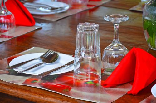 a wooden table with red napkins and a wine glass at Ocean View Nyali Boutique Hotel in Nyali
