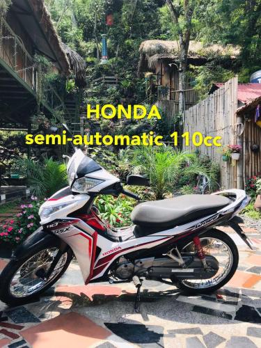 a motorcycle parked in a yard with the words hondaennaennaulic at Green Hill Hostel & Tour in Ha Giang