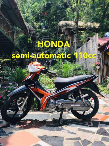 a motor bike parked on a sidewalk in a garden at Green Hill Hostel & Tour in Ha Giang