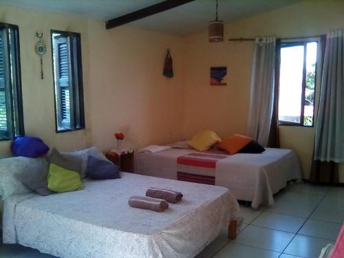 um quarto com 2 camas, um sofá e janelas em Casa das Gaúchas em Canoa Quebrada