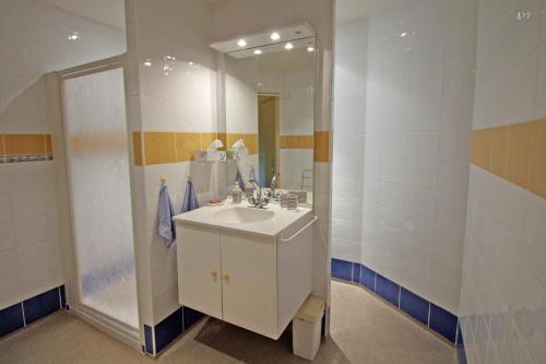 une salle de bain avec un lavabo blanc et un miroir dans l'établissement chambres d'hotes les quatre vents, à Bussière-Galant