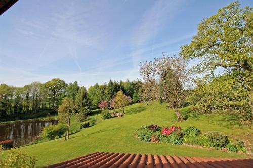 une colline verdoyante avec un jardin et un étang dans l'établissement chambres d'hotes les quatre vents, à Bussière-Galant