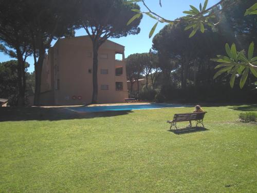 a person sitting on a park bench in the grass at porta del golf in Pals