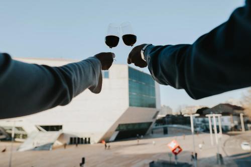 a pair of hands with glasses in front of a building at Five Seven Nine Apartments in Porto