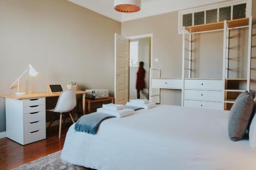 a bedroom with a white bed and a desk at Five Seven Nine Apartments in Porto