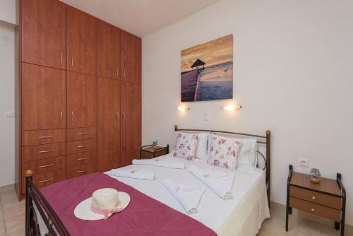 a bedroom with a bed and a table with a hat on it at Domus Lukas Apartments in Marathias