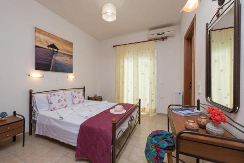 a bedroom with a bed and a table and a mirror at Domus Lukas Apartments in Marathias