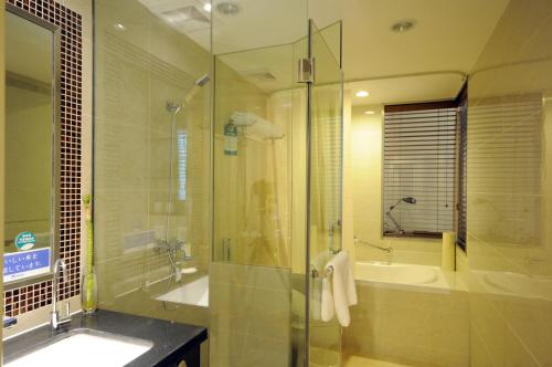 a bathroom with a shower and a sink and a tub at Gubei Garden Hotel Shanghai Hongqiao in Shanghai