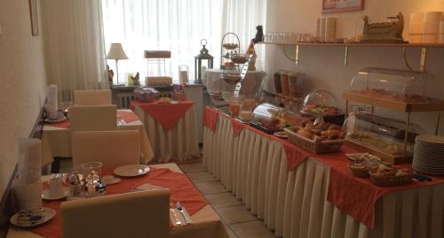 uma sala com mesas e cadeiras com comida em Hotel Am Ufer em Trier
