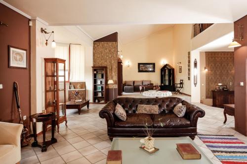 a living room with a brown leather couch in a room at Villa Loridis in Prinos