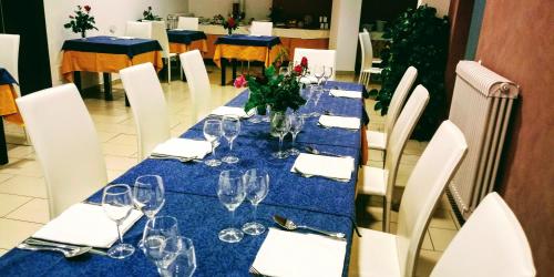 a table with a blue table cloth and wine glasses at Hotel 660 in Bisignano