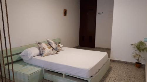 1 dormitorio con 1 cama con sábanas y almohadas blancas en Habitación Independiente Sur - Cali en Cali