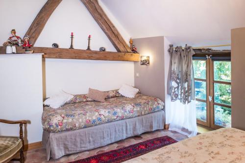 Corcelles-les-ArtsにあるLa Cuverie du Châteauのベッドと窓のある寝室