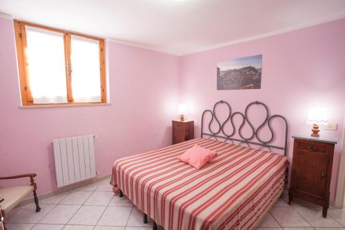 una camera da letto con un letto con un cuscino rosa di Casa Malva a Portoferraio