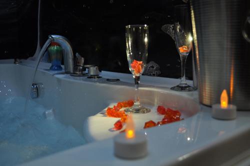 a bath tub with two champagne glasses and candles at Villa Dislievski in Ohrid