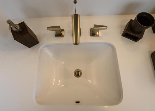a white sink with a gold faucet on a counter at Villa Topaz Above West Bay with 180 degree views! in West Bay