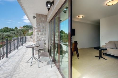 a balcony with a table and chairs and a couch at Adria Lux Apartments Sveti Stefan in Budva