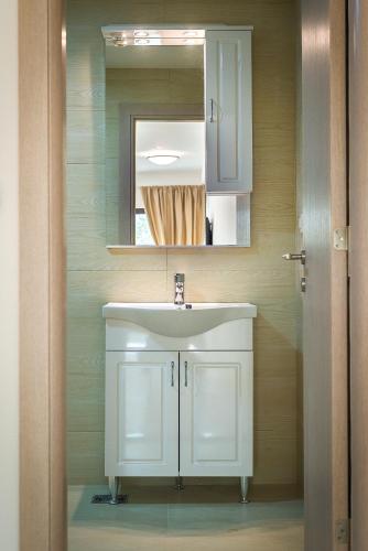 a bathroom with a white sink and a mirror at Adria Lux Apartments Sveti Stefan in Budva