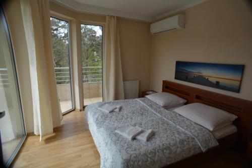 a bedroom with a bed with two towels on it at Floryda Jurata in Jurata