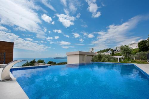 a swimming pool in a villa with a blue sky at Adria Lux Apartments Sveti Stefan in Budva