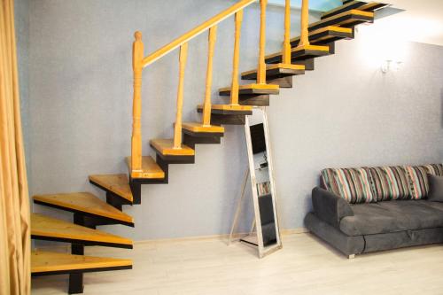 a staircase in a living room with a couch at Apartments Of Aurumi in Tbilisi City