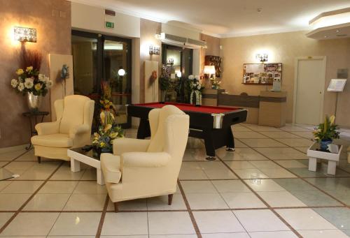 a waiting room with a pool table and chairs at Hotel Busignani in Rimini