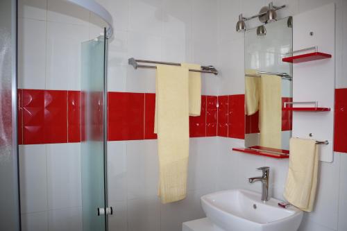 a bathroom with a sink and red and white tiles at Hôtel Maisons-Sifa in Butare