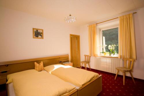 1 dormitorio con cama y ventana en Gasthof Steg, en Campodazzo