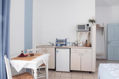 a small kitchen with a table and a microwave at Calderimi Apartments in Fira