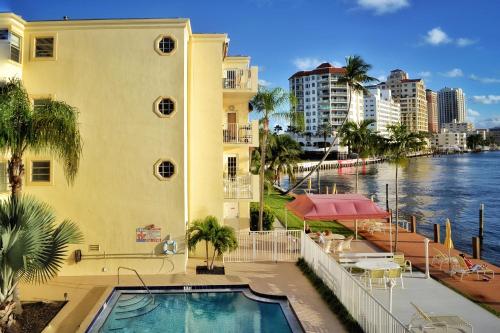a building with a swimming pool next to a river at Fort Lauderdale Yacht and Beach Club 416 in Fort Lauderdale